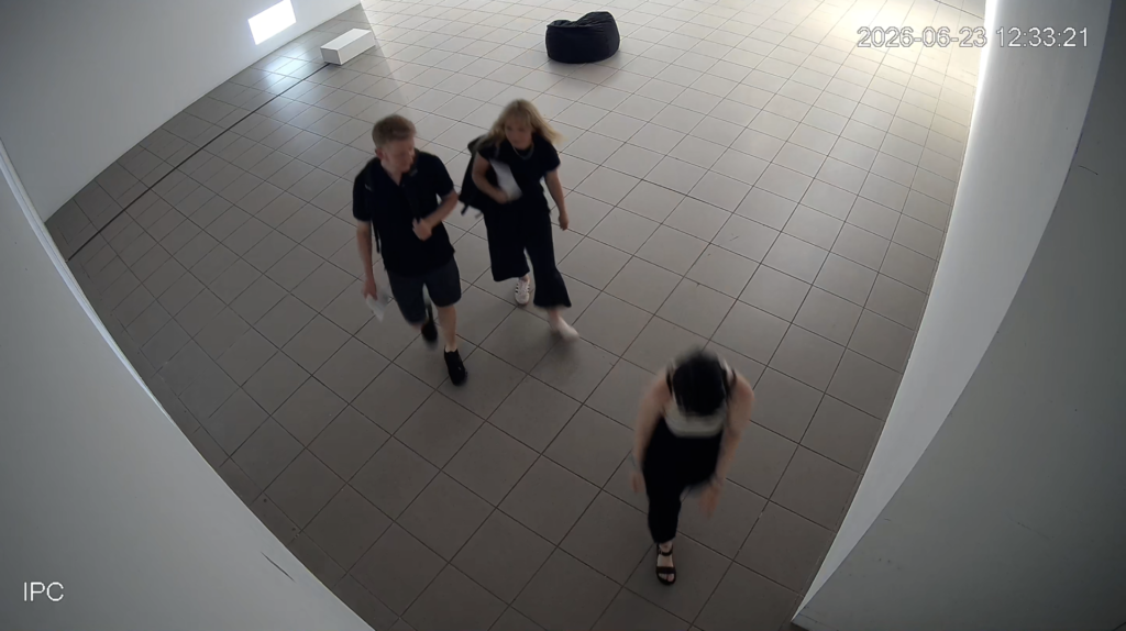 Ujęcie sali BWA z kamery przemysłowej, troje ludzi